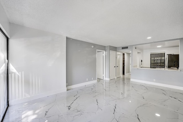 unfurnished room featuring a textured ceiling