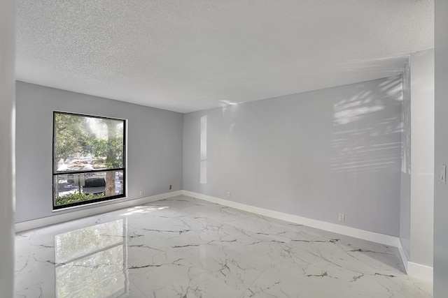 unfurnished room featuring a textured ceiling