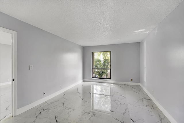 unfurnished room with a textured ceiling