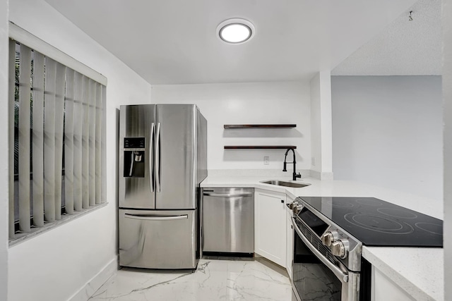 kitchen featuring stainless steel appliances, white cabinetry, and sink