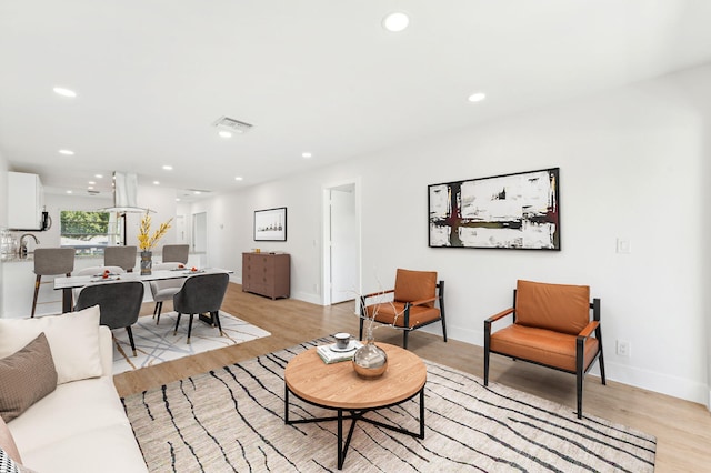 living room with sink and light hardwood / wood-style floors