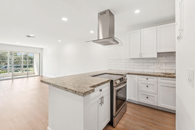 kitchen with electric stove, island range hood, light hardwood / wood-style flooring, and white cabinets