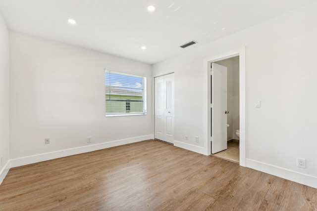 unfurnished bedroom with light hardwood / wood-style floors and a closet