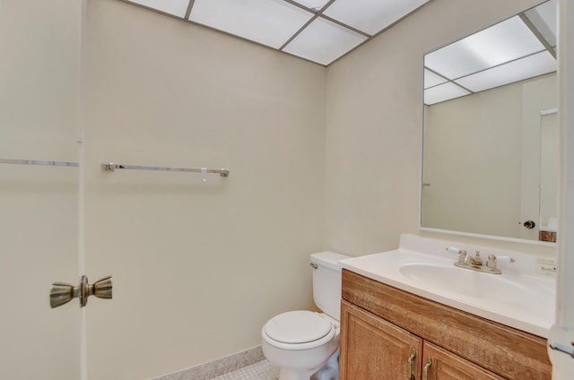 bathroom with vanity, a paneled ceiling, toilet, and tile patterned flooring