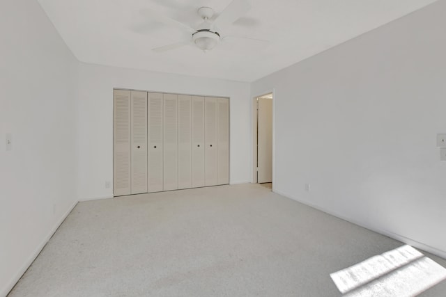 unfurnished bedroom featuring a closet, ceiling fan, and light colored carpet