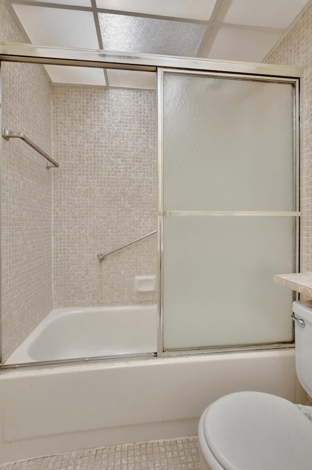 full bathroom featuring combined bath / shower with glass door, vanity, toilet, and tile patterned flooring