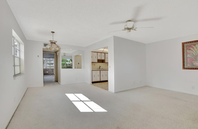 carpeted spare room featuring ceiling fan, a textured ceiling, and sink