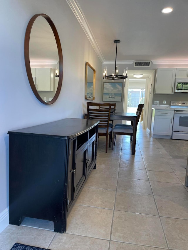 interior space with white electric range oven, light tile patterned floors, ornamental molding, decorative light fixtures, and a notable chandelier