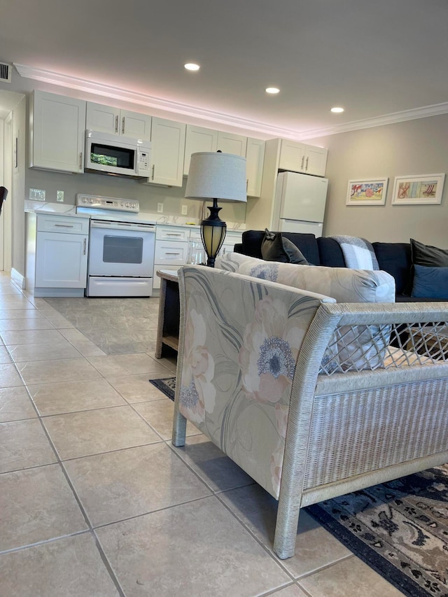 interior space featuring crown molding, white appliances, light tile patterned floors, and white cabinets