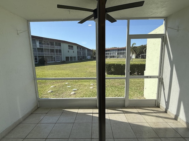 unfurnished sunroom featuring ceiling fan