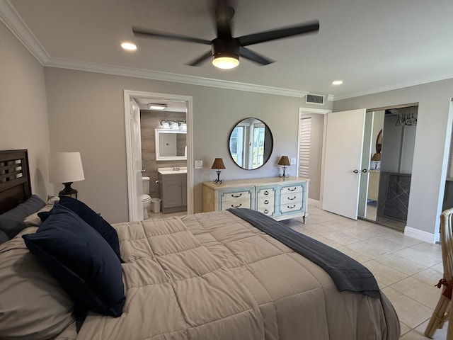 bedroom with visible vents, ornamental molding, baseboards, light tile patterned floors, and ensuite bath