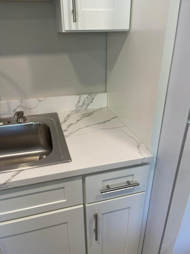 room details with light stone countertops and sink