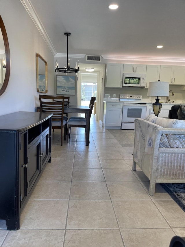 kitchen with visible vents, light countertops, a notable chandelier, ornamental molding, and white appliances