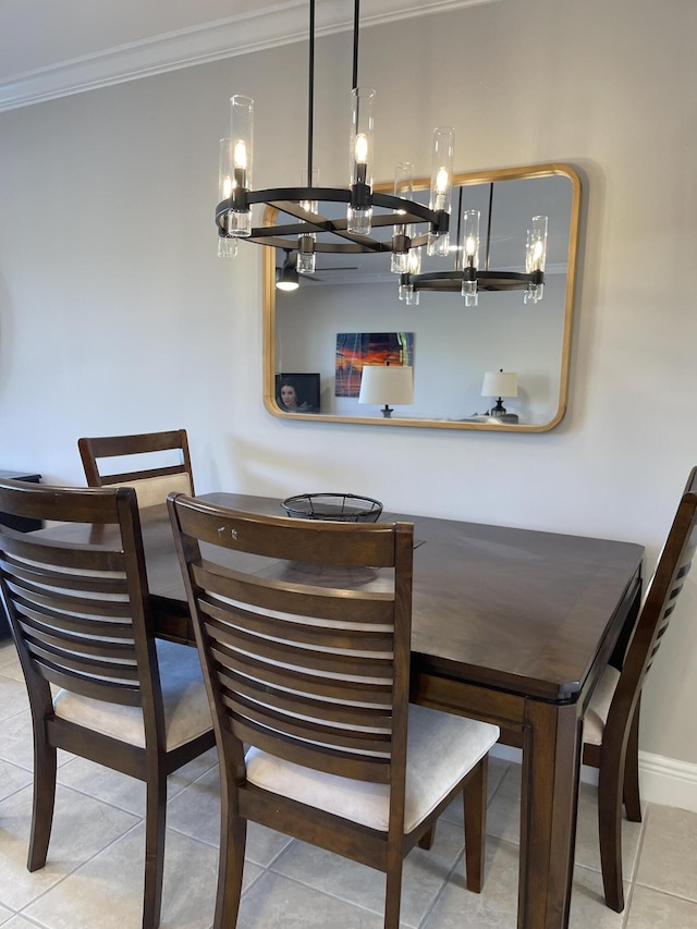 dining area with an inviting chandelier, baseboards, crown molding, and tile patterned floors
