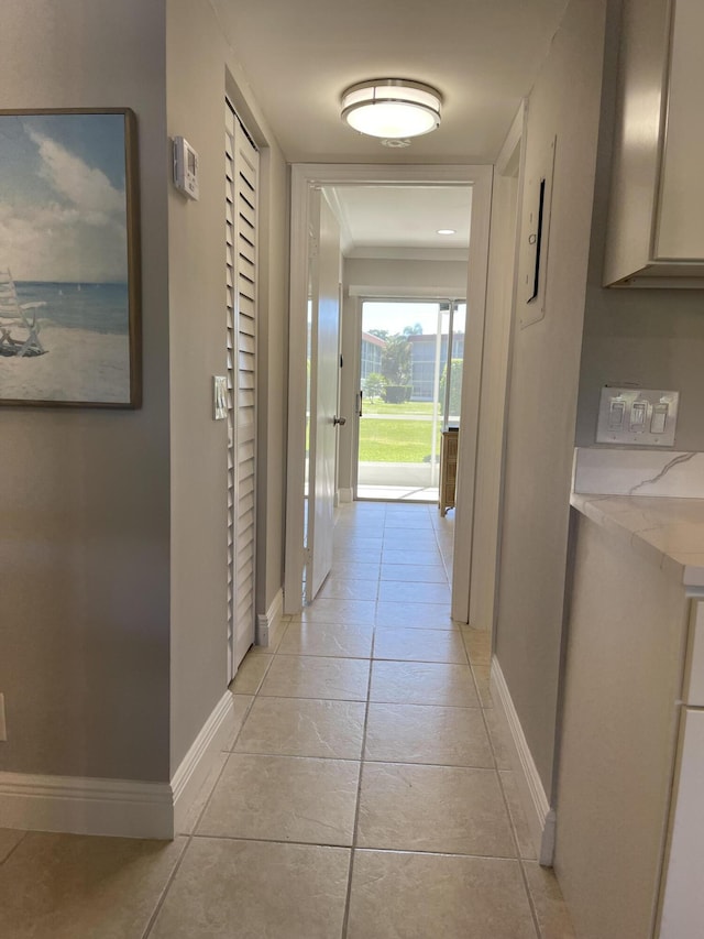 hallway featuring baseboards and light tile patterned floors