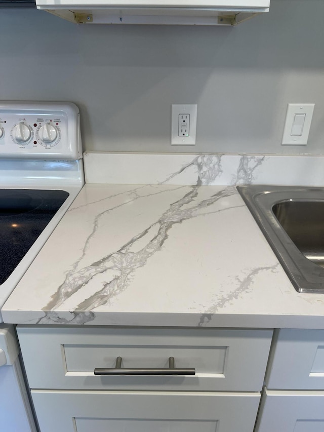 room details featuring electric range, light stone countertops, and a sink