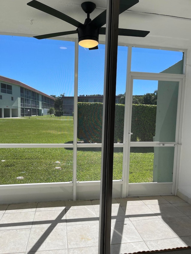 unfurnished sunroom featuring ceiling fan