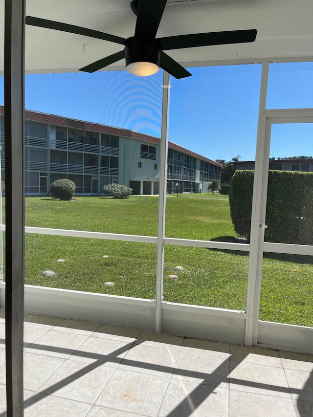 unfurnished sunroom with ceiling fan