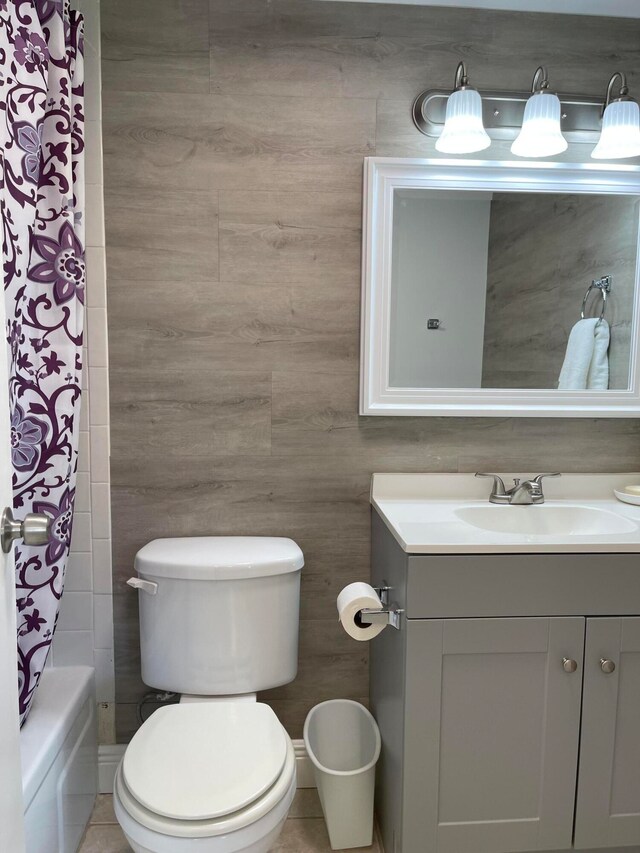 full bathroom featuring vanity, toilet, tile walls, tile patterned flooring, and shower / tub combo with curtain