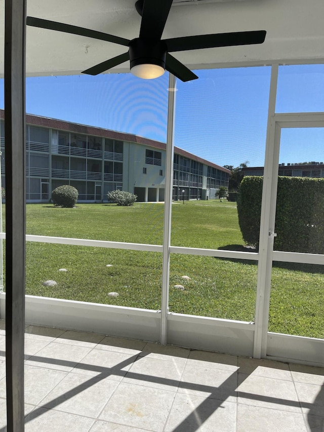 unfurnished sunroom featuring a ceiling fan