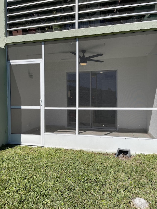exterior space with a yard, a ceiling fan, and a balcony