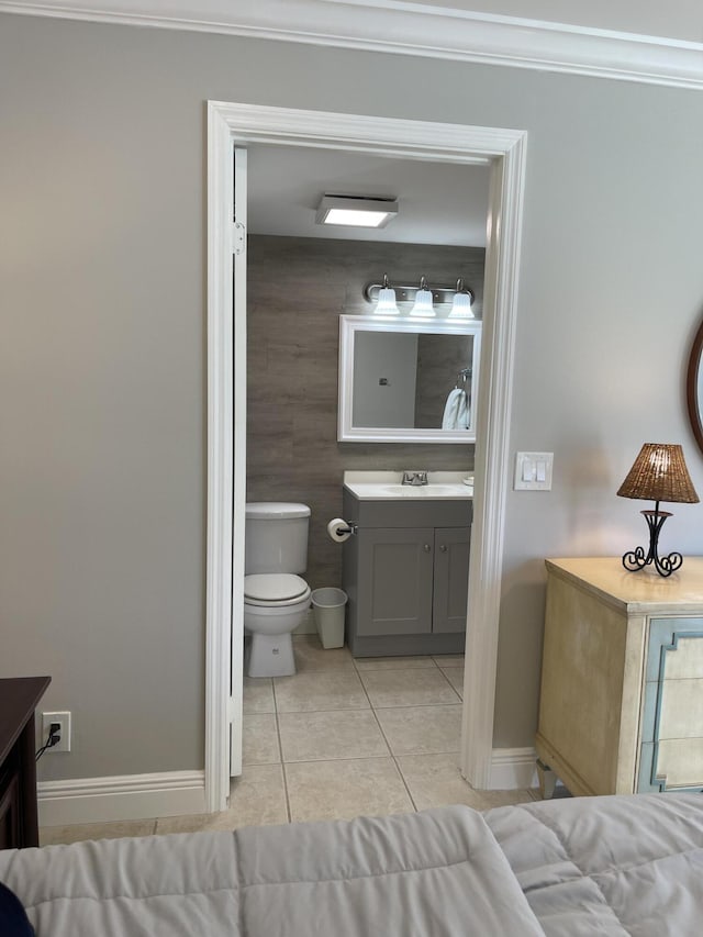 bathroom featuring crown molding, baseboards, tile patterned flooring, and vanity