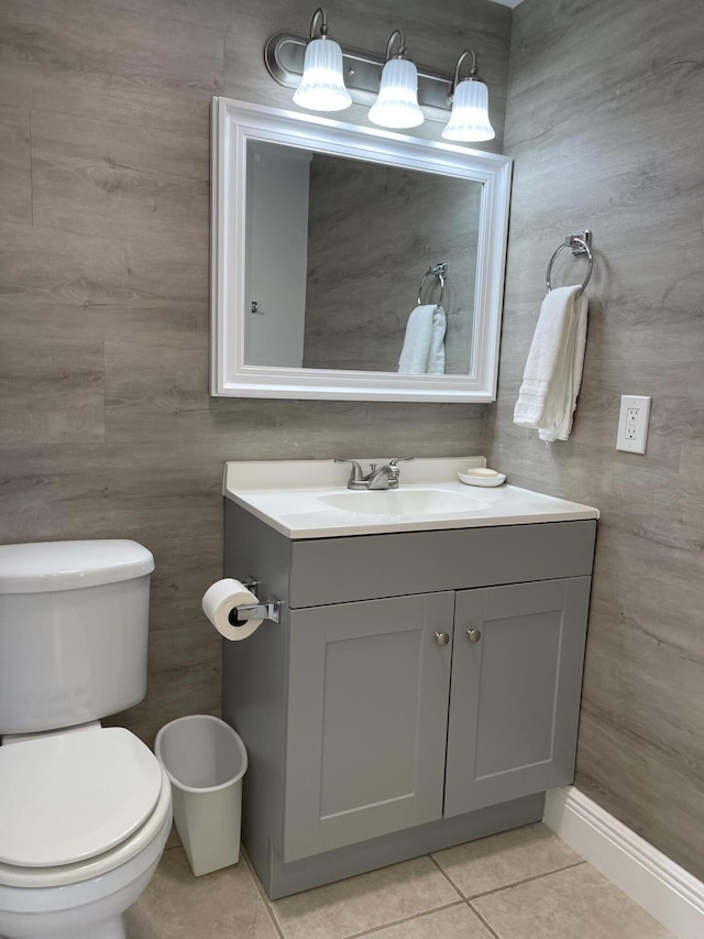 half bath with tile patterned flooring, toilet, and vanity