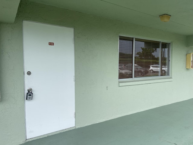 view of exterior entry with stucco siding