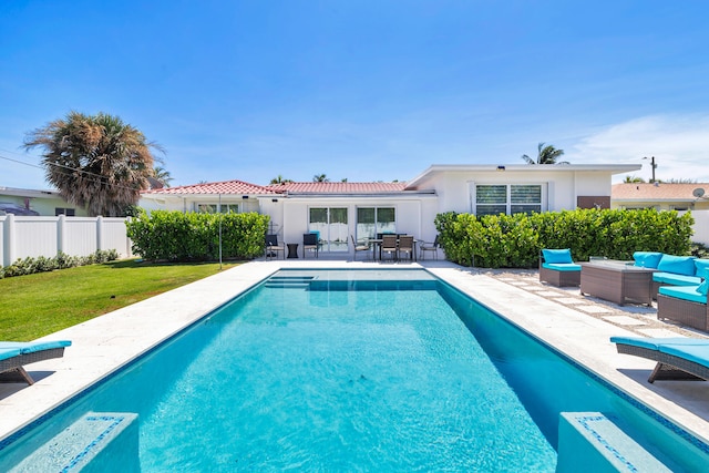 view of swimming pool with an outdoor living space, a patio, and a lawn