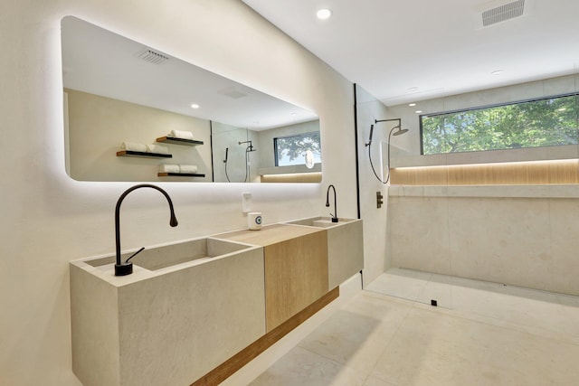 bathroom featuring a tile shower, tile patterned flooring, and vanity