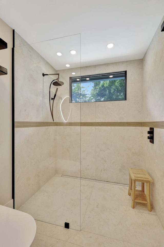 bathroom featuring tile walls, plenty of natural light, and tiled shower