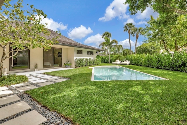 view of swimming pool with a yard and a patio