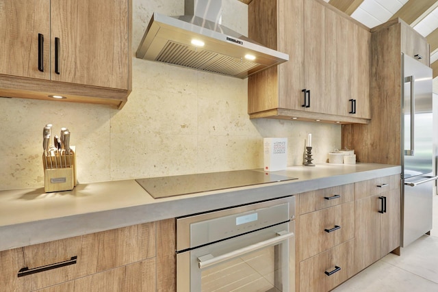 kitchen featuring black electric stovetop, tasteful backsplash, wall chimney range hood, oven, and high end fridge