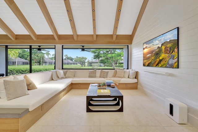 living room with vaulted ceiling with beams, wood walls, plenty of natural light, and light tile patterned floors