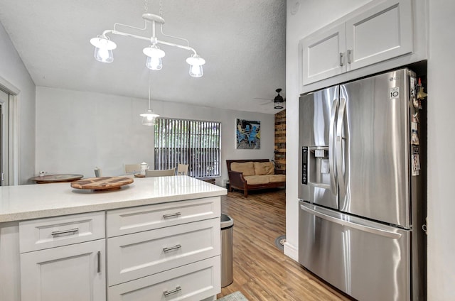 kitchen with white cabinets, a textured ceiling, decorative light fixtures, light hardwood / wood-style floors, and stainless steel fridge with ice dispenser