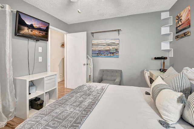 bedroom with light wood-type flooring and a textured ceiling