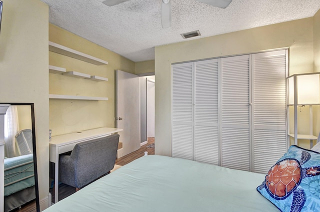 bedroom featuring ceiling fan, a closet, a textured ceiling, and hardwood / wood-style flooring