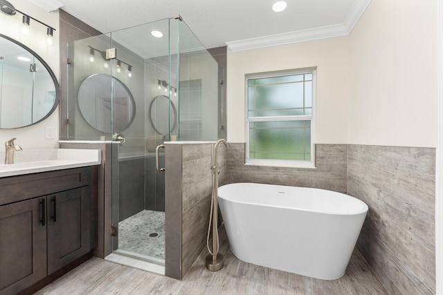 bathroom with vanity, separate shower and tub, tile walls, crown molding, and hardwood / wood-style floors