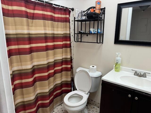 bathroom with vanity, tile patterned flooring, toilet, and curtained shower