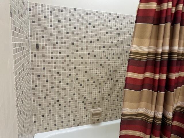 bathroom featuring shower / bath combo and tile walls