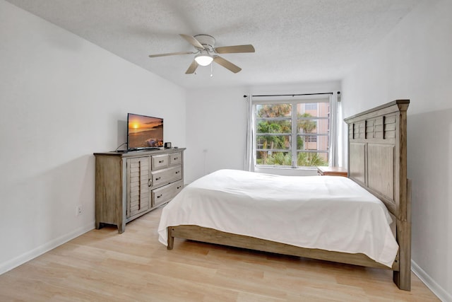 bedroom featuring a textured ceiling, light wood-type flooring, and ceiling fan