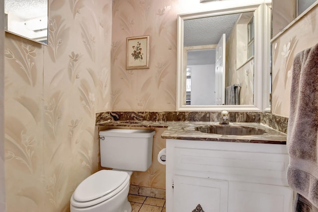 bathroom featuring vanity, a textured ceiling, toilet, and tile patterned flooring