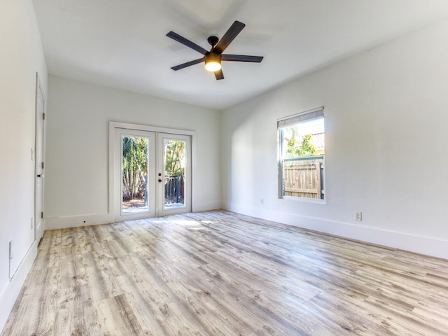 spare room featuring a ceiling fan, baseboards, wood finished floors, and french doors