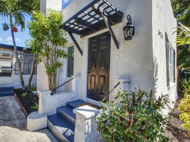 view of exterior entry with stucco siding