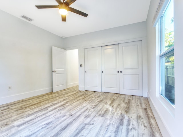 unfurnished bedroom featuring ceiling fan, light wood-type flooring, and a closet