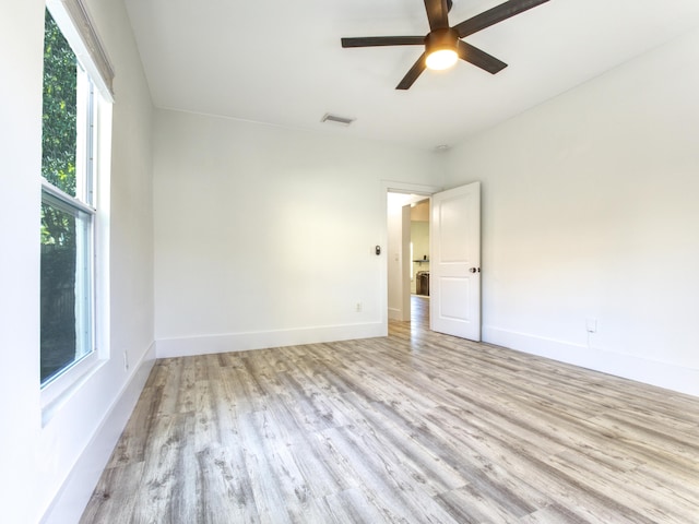 empty room with light hardwood / wood-style floors, ceiling fan, and a healthy amount of sunlight