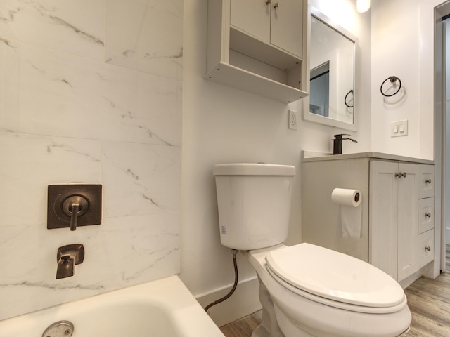 bathroom featuring hardwood / wood-style floors, toilet, and a tub