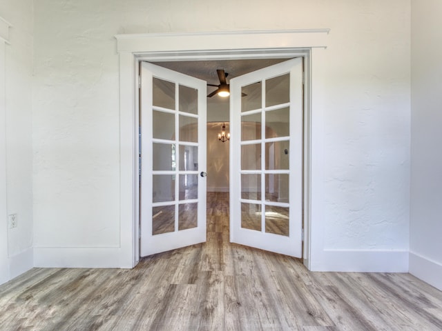 interior details featuring french doors, ceiling fan with notable chandelier, and hardwood / wood-style floors