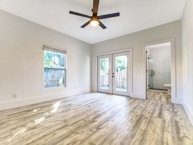 spare room with french doors, wood finished floors, and a healthy amount of sunlight