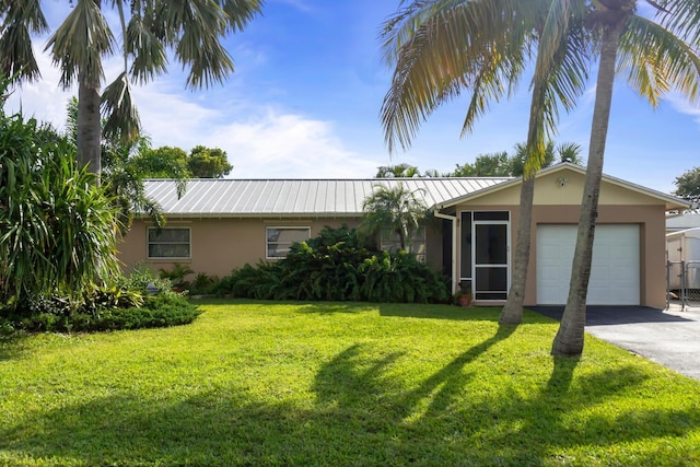 single story home featuring a garage and a front lawn